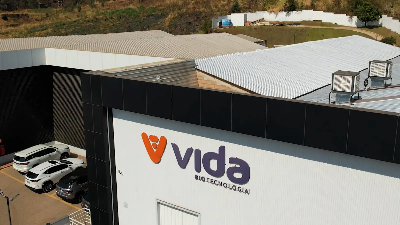 Fachada da sede da VIDA com o letreiro, vista de um drone que se afasta e mostra os telhados